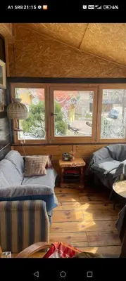 a living room with two beds and two windows at kuća za odmor marković in Kopaonik