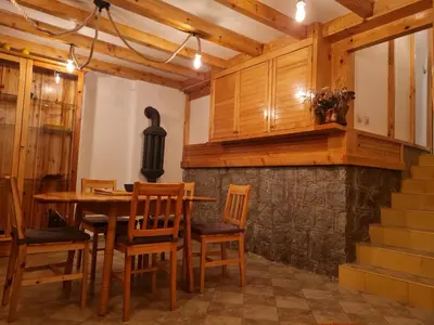 a dining room with a wooden table and chairs at Mountain House Mijatović in Kopaonik