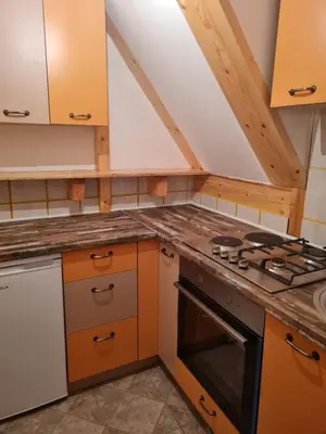 a kitchen with orange cabinets and a stove top oven at Mountain House Mijatović in Kopaonik