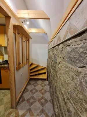 a kitchen with a stone wall and a stairway at Mountain House Mijatović in Kopaonik