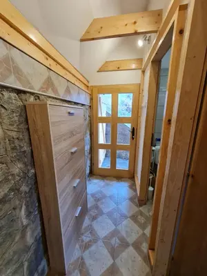 a bathroom with wooden doors and a tiled floor at Mountain House Mijatović in Kopaonik