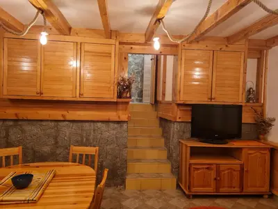 a dining room with a table and a television at Mountain House Mijatović in Kopaonik
