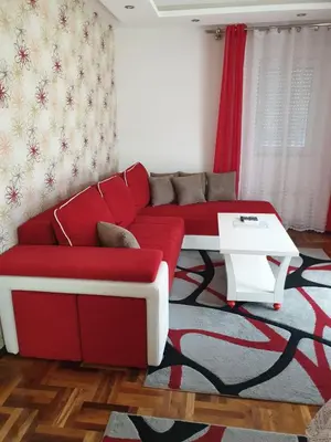 a living room with a red couch and a table at Lux Apartman Ristić 2 in Soko Banja