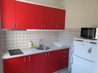 a kitchen with red cabinets and a sink at Lux Apartman Ristić 2 in Soko Banja