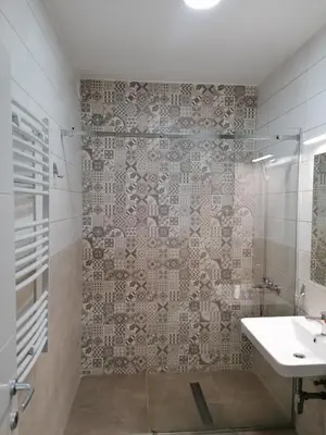 a bathroom with a shower and a sink and a mirror at Apartman Div Kopaonik in Kopaonik