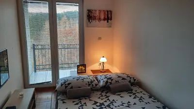 a bedroom with a bed and a table with a lamp at Apartman Pogled Sokobanja in Soko Banja