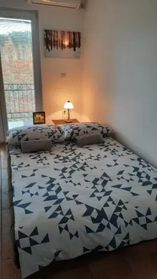 a bedroom with a bed with a blue and white comforter at Apartman Pogled Sokobanja in Soko Banja