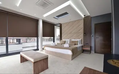 a bedroom with a large bed and a large window at Spa Resort & Hotel Vrnjačke Terme in Vrnjačka Banja