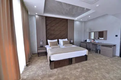 a bedroom with a large bed with a desk and a bed sidx sidx sidx sidx at Spa Resort & Hotel Vrnjačke Terme in Vrnjačka Banja