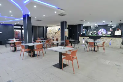 a restaurant with tables and chairs and a bar at Spa Resort & Hotel Vrnjačke Terme in Vrnjačka Banja