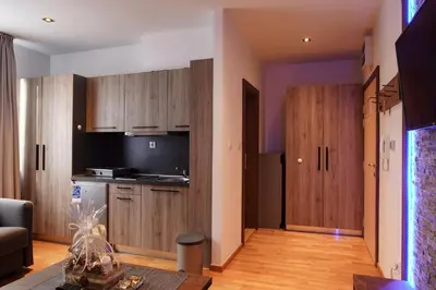 a kitchen with wooden cabinets and a table in a room at FeelSTONE apartmani Brzeće in Brzeće