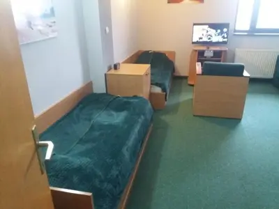 a hotel room with two beds and a tv at Kopaonik Vila Nikola 306 centar in Kopaonik