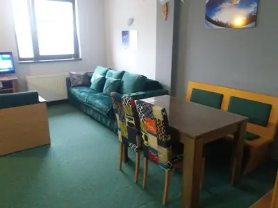 a living room with a couch and a table at Kopaonik Vila Nikola 306 centar in Kopaonik