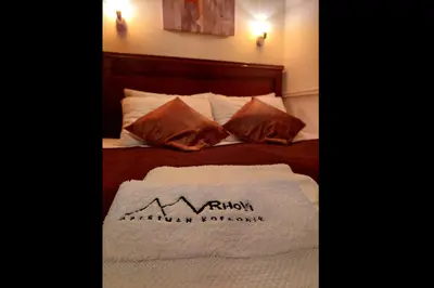 a hotel room with a bed with a mountain towel on it at Apartman Vrhovi Kopaonik Vila Nikola Centar in Kopaonik