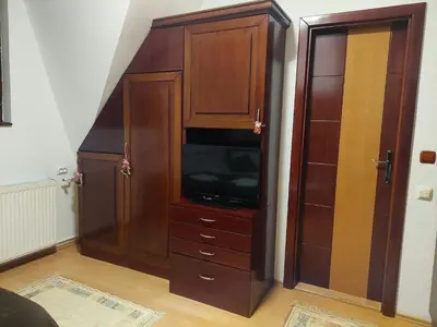 a large wooden cabinet with a television in it at Apartman Vrhovi Kopaonik Vila Nikola Centar in Kopaonik