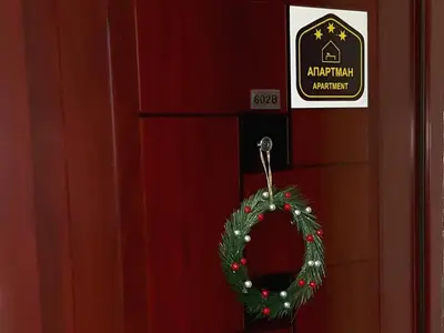 a christmas wreath is hanging on a red door at Apartman Vrhovi Kopaonik Vila Nikola Centar in Kopaonik