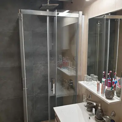a bathroom with a shower with a sink and a mirror at Apartman Noalux Kopaonik in Kopaonik