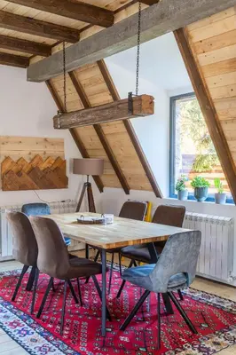 a dining room with a wooden table and chairs at Kežman Mountain Houses in Kopaonik