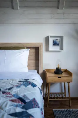 a bedroom with a bed and a nightstand with a bed sidx sidx at Kežman Mountain Houses in Kopaonik