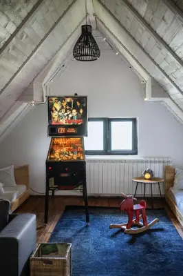 a living room with a flat screen tv in a attic at Kežman Mountain Houses in Kopaonik
