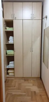 a closet with white cabinets and a wooden floor at Apartman Nikola- 4 ZVEZDICE minimalno 3 nocenja za rezervaciju in Vrnjačka Banja