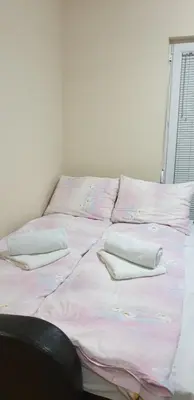 a bed with pink sheets and pillows on it at Apartman Nikola- 4 ZVEZDICE minimalno 3 nocenja za rezervaciju in Vrnjačka Banja