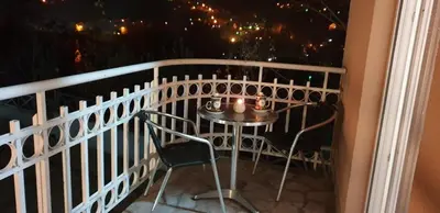 a table and chairs on a balcony at night at Apartman Nikola- 4 ZVEZDICE minimalno 3 nocenja za rezervaciju in Vrnjačka Banja