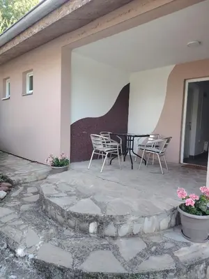 a patio with chairs and a table on a house at Apartmani Mihajlovic Sisevac in Sisevac