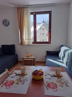 a living room with a table with a bowl of fruit at Vila Irina Kopaonik in Kopaonik