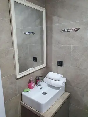 a bathroom with a white sink and a mirror at Milmari Resort - Lux Apartment in Kopaonik
