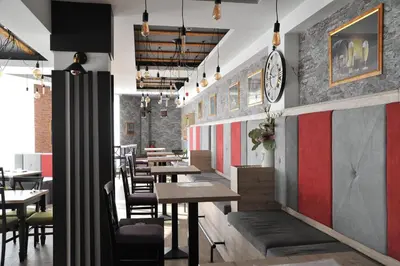 a restaurant with tables and chairs and a clock on the wall at Milmari Resort - Lux Apartment in Kopaonik