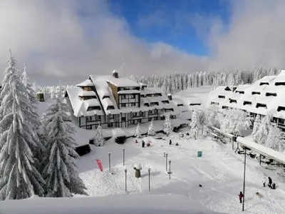 a resort in the snow with snow covered trees at Apartman SREBRNA PAHULjA-Konaci in Kopaonik