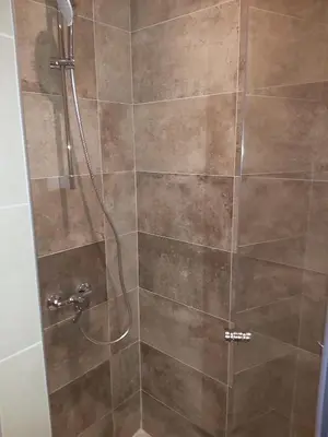 a bathroom with a shower with a glass door at Apartman SREBRNA PAHULjA-Konaci in Kopaonik