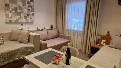 a living room with a couch and a table at Apartman SREBRNA PAHULjA-Konaci in Kopaonik