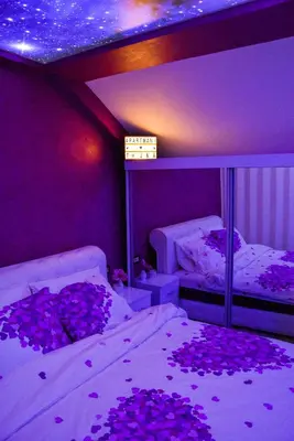 a bedroom with two beds covered in purple flowers at Apartmani Tajna in Paraćin