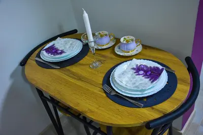 a wooden table with plates and a candle on it at Apartmani Tajna in Paraćin