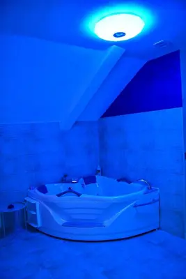 a white tub in a room with a blue light at Apartmani Tajna in Paraćin