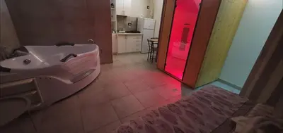 a bathroom with a white sink and a red light at Apartmani Tajna in Paraćin