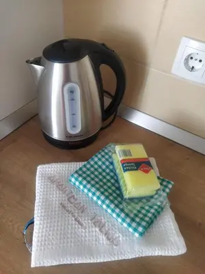 a tea kettle and a book on a table at Talija Apartman in Vrnjačka Banja