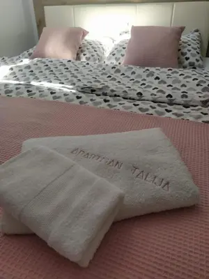 two towels are sitting on top of a bed at Talija Apartman in Vrnjačka Banja