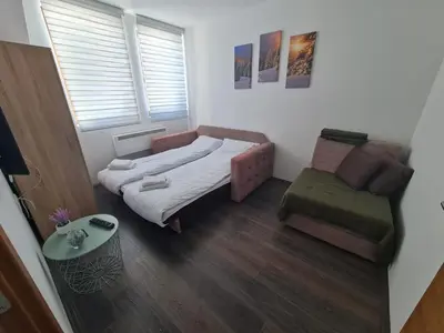 a small bedroom with a bed and a chair at Sunčani Breg-Sunčana KOP studio in Kopaonik