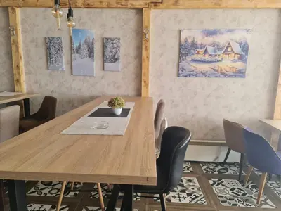 a dining room with a wooden table and chairs at Sunčani Breg-Sunčana KOP studio in Kopaonik