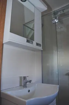 a bathroom with a sink and a mirror and a shower at Sunčani Breg-Sunčana KOP studio in Kopaonik