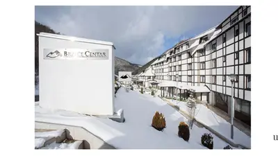 a building with a sign in the snow at Apartman Davidović in Brzeće