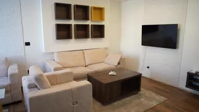 a living room with a couch and a tv at Bella apartments in Kruševac