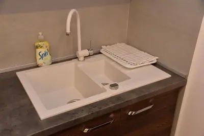 a bathroom with a white sink and a faucet at Bella apartments in Kruševac