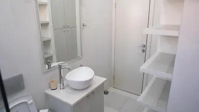 a white bathroom with a sink and a mirror at Bella apartments in Kruševac