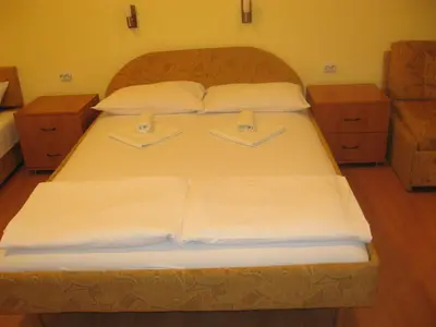 a large bed with white sheets and pillows at Apartmani Marković in Soko Banja