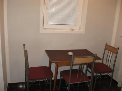 a small table and chairs in a room with a window at Apartmani Marković in Soko Banja