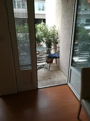 a sliding glass door leading to a patio with a table at Apartmani Marković in Soko Banja